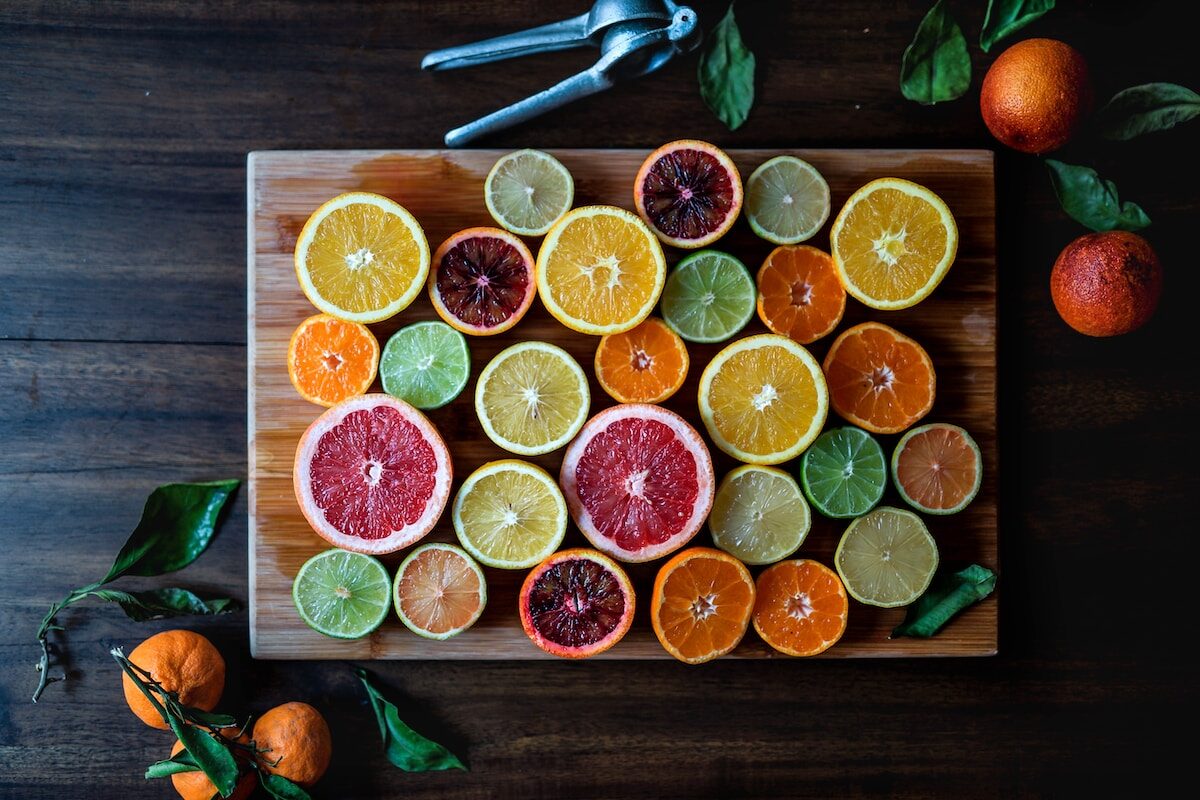 assorted sliced citrus fruits on brown wooden chopping board